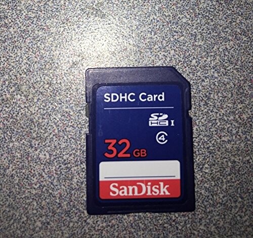 SanDisk 32GB SDHC memory card on a speckled surface.